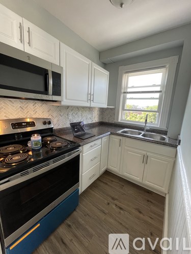 A kitchen with a blue stove top oven and white cabinets.