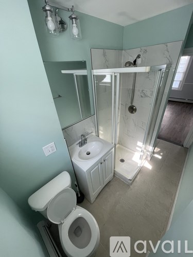 A bathroom with a toilet, sink, and shower.