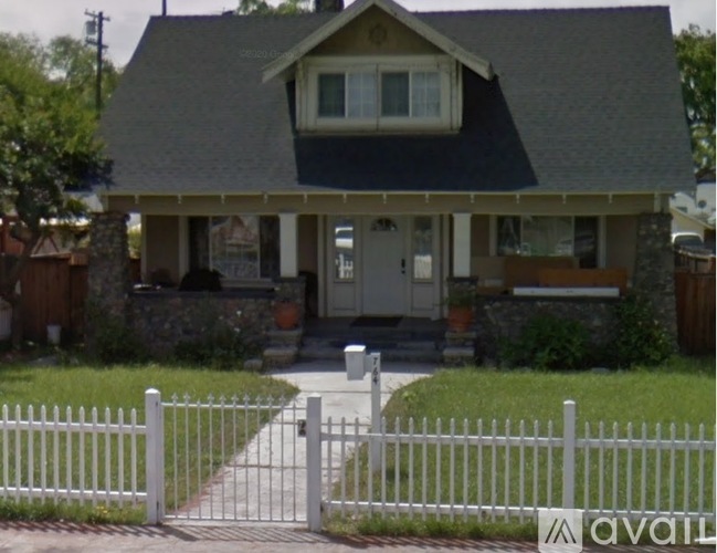 A house with a white picket fence in front.