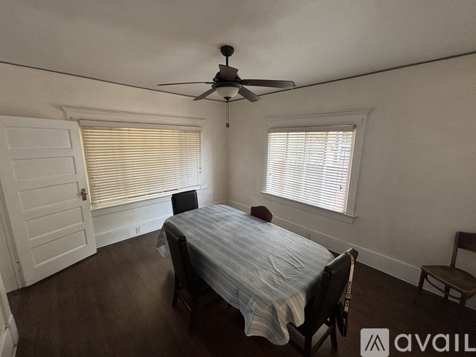 A bedroom with a bed, chair, and ceiling fan.