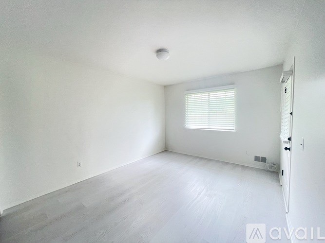 A spacious room with a window and a door.