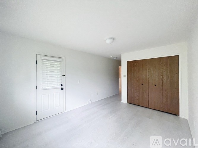 A room with a white door and a wooden cabinet.