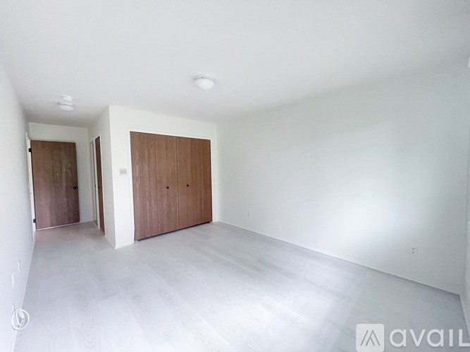 A room with two brown doors and a white wall.