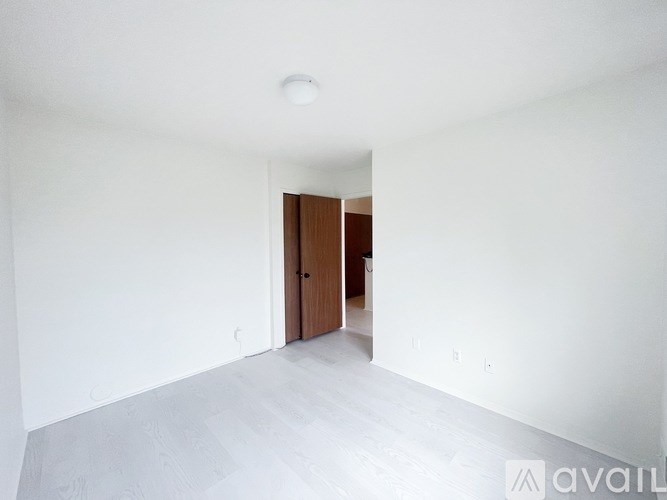 A room with a white wall and a wooden door.