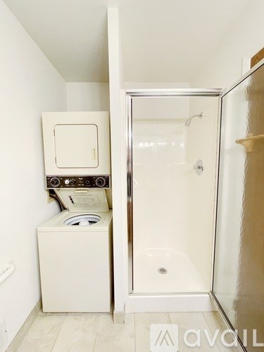 A white washer and dryer in a small bathroom.