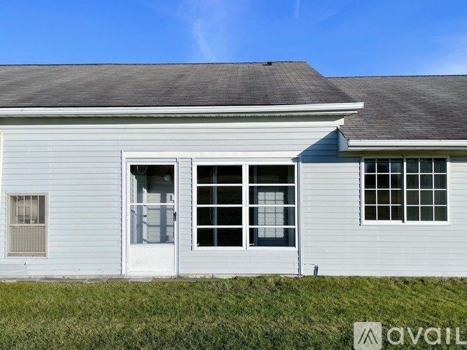 A house with a white door and windows is for sale.
