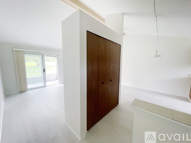 A room with a brown door and a white wall.