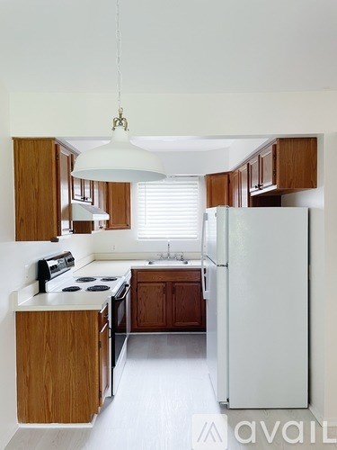 A kitchen with wooden cabinets and a white refrigerator.