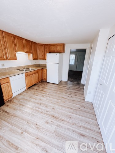A kitchen with wooden cabinets and a white refrigerator.