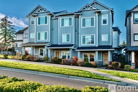 A row of modern townhouses with a clear blue sky above them.