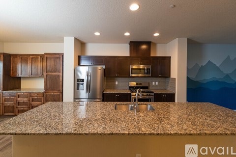 A kitchen with granite countertops and wooden cabinets.