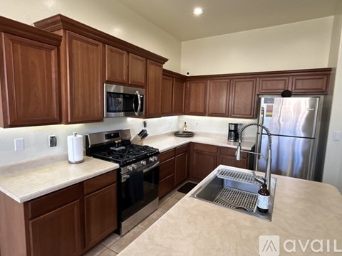 A kitchen with brown cabinets and a black stove top.