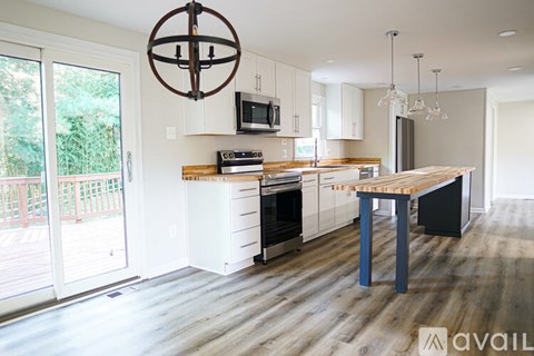 A modern kitchen with white cabinets and a wooden island.