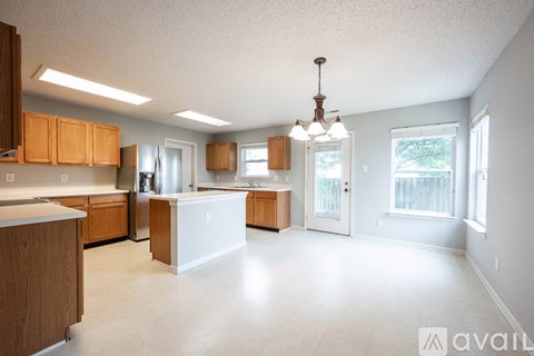 A kitchen with wooden cabinets and a white island.