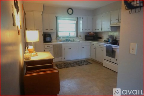 A kitchen with white cabinets and a brown drawer.