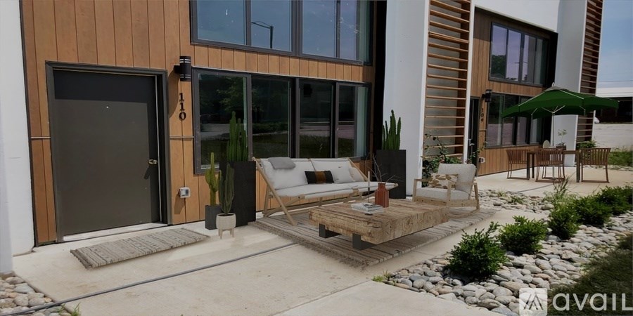 A modern house with a wooden exterior and a patio with a couch and chairs.