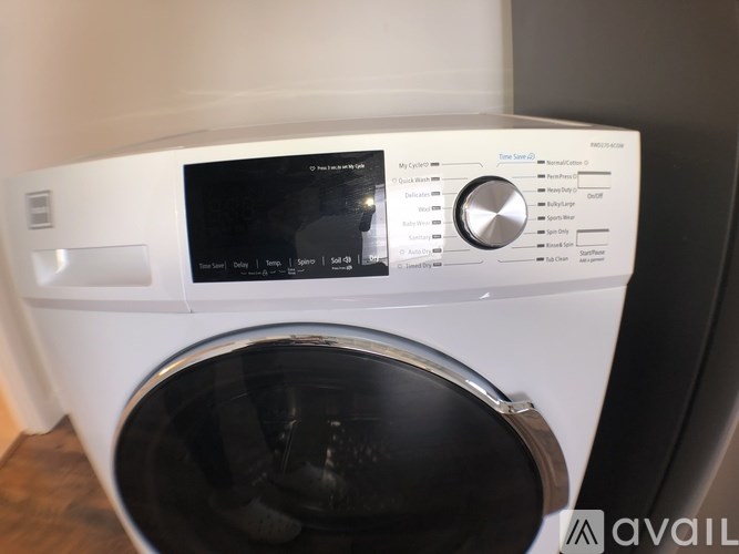 A front-loading washing machine with a digital display and control panel.