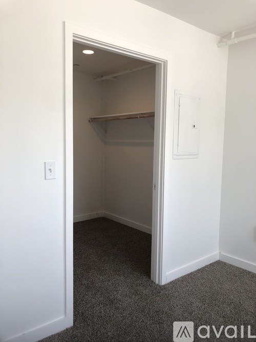 A small white closet with a shelf and a light switch.