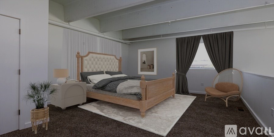 A bedroom with a large bed and a chair.