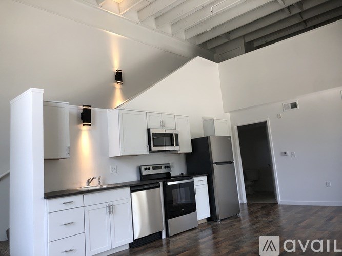 A kitchen with white cabinets and black appliances.