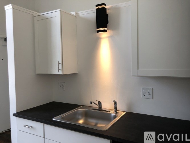 A modern kitchen with a black countertop and white cabinets.