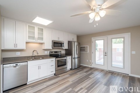 A kitchen with white cabinets and a wood floor.