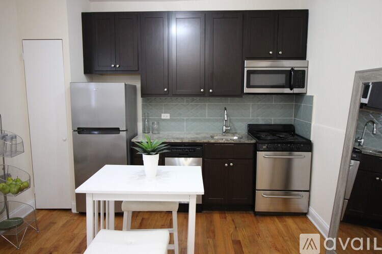 A kitchen with a white table and black cabinets.