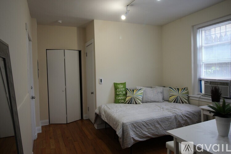 A bedroom with a bed, a wardrobe, and a window.