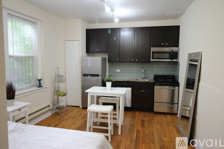 A kitchen with black cabinets and stainless steel appliances.