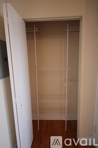 A white closet with shelves and a door open.