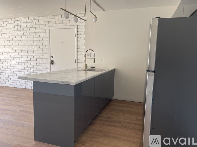 A kitchen with a white brick wall and a grey island.