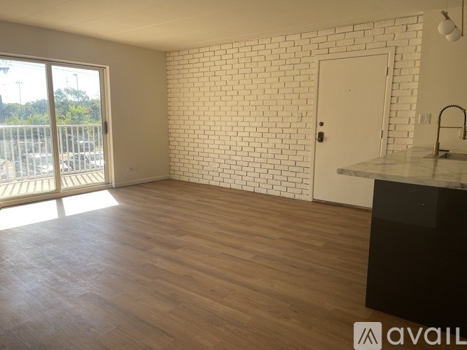 A room with a white brick wall and wooden flooring.