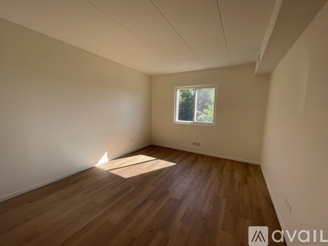 Empty room with wooden floor and a window.