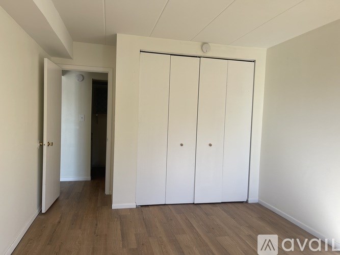 A room with a white door and three white cupboards.