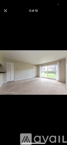 A room with a carpeted floor and a door leading outside.