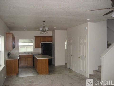 A kitchen with wooden cabinets and a black fridge.