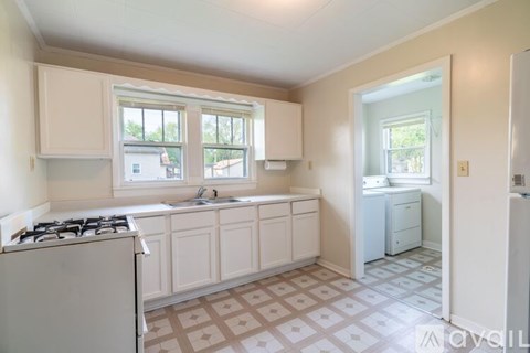 A kitchen with a white refrigerator, a gas stove, and a sink.