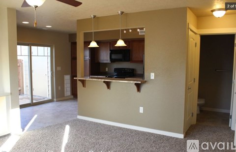 A living room with a kitchen area in the background.