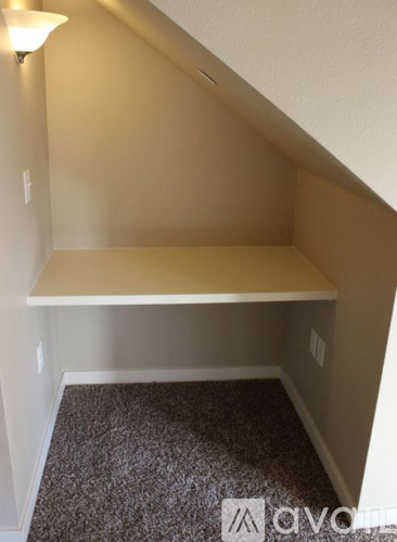 A small room with a carpeted floor and a white bench.