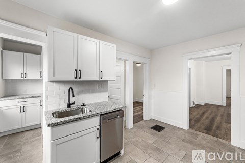 A kitchen with white cabinets and a stainless steel dishwasher.