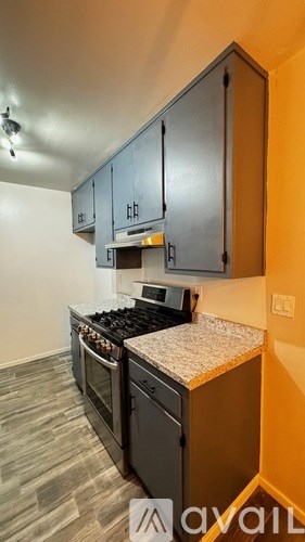 A kitchen with black cabinets and a stove top oven.