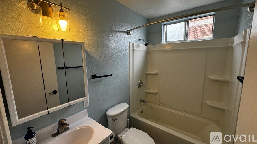 A bathroom with a toilet, sink, and bathtub.
