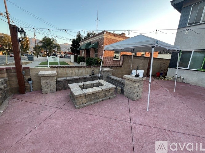 A patio with a pink surface and a white tent.