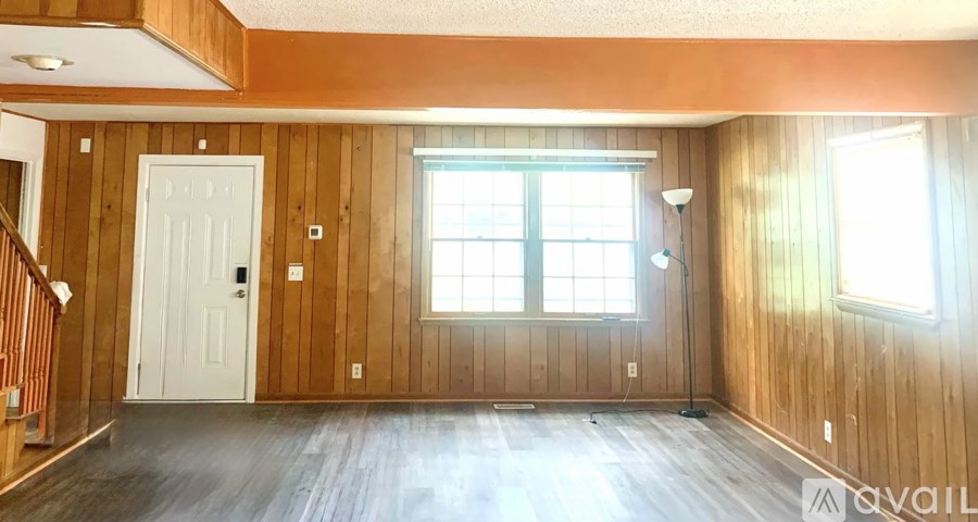 A room with wooden walls and a white door.