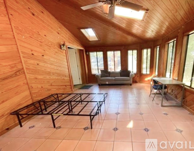A wooden room with a table and chairs.