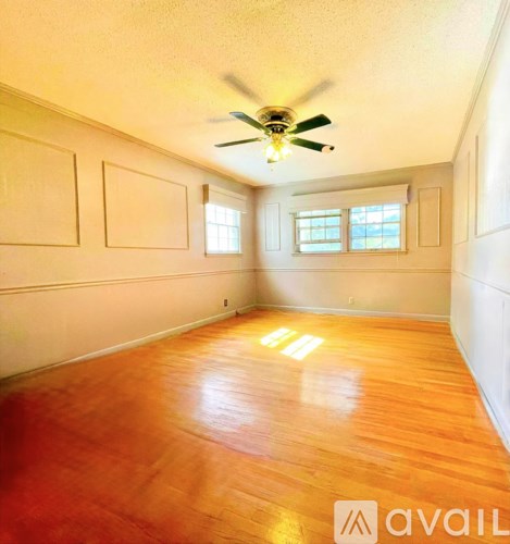 A room with wooden floors and a ceiling fan.