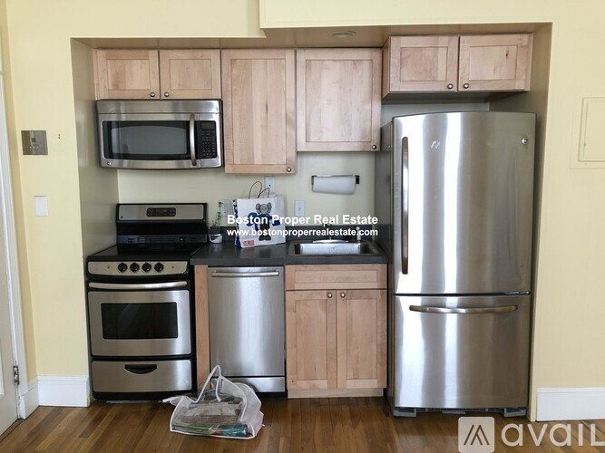 A kitchen with a stainless steel refrigerator, oven, and microwave.