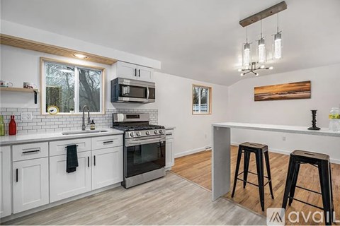 A kitchen with white cabinets and a black stove top oven.