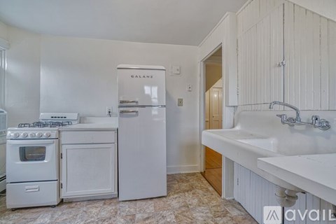A kitchen with white appliances and cabinets.