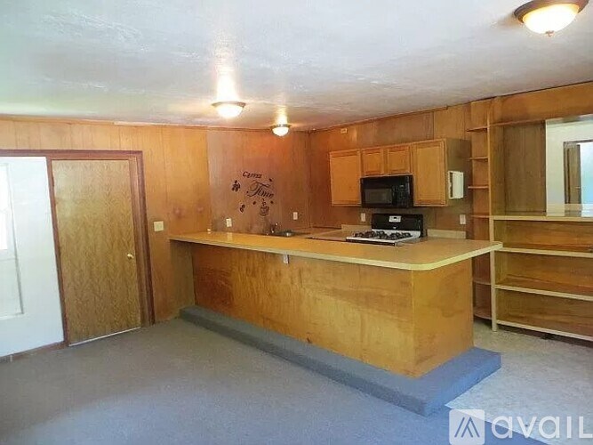 A kitchen with wooden cabinets and a microwave.